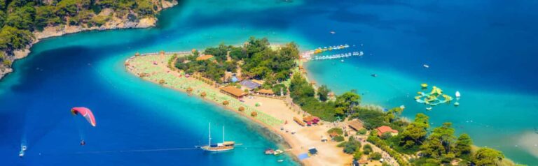 Aerial view of Ölüdeniz Blue Lagoon with turquoise water, sandy beach, and paragliders near Fethiye, Turkey