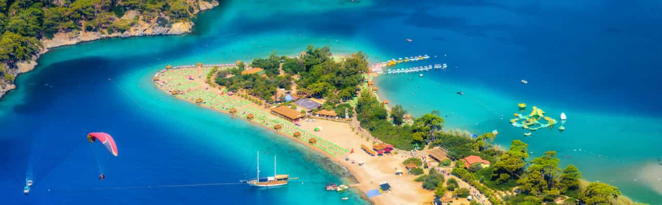 Aerial view of Ölüdeniz Blue Lagoon with turquoise water, sandy beach, and paragliders near Fethiye, Turkey